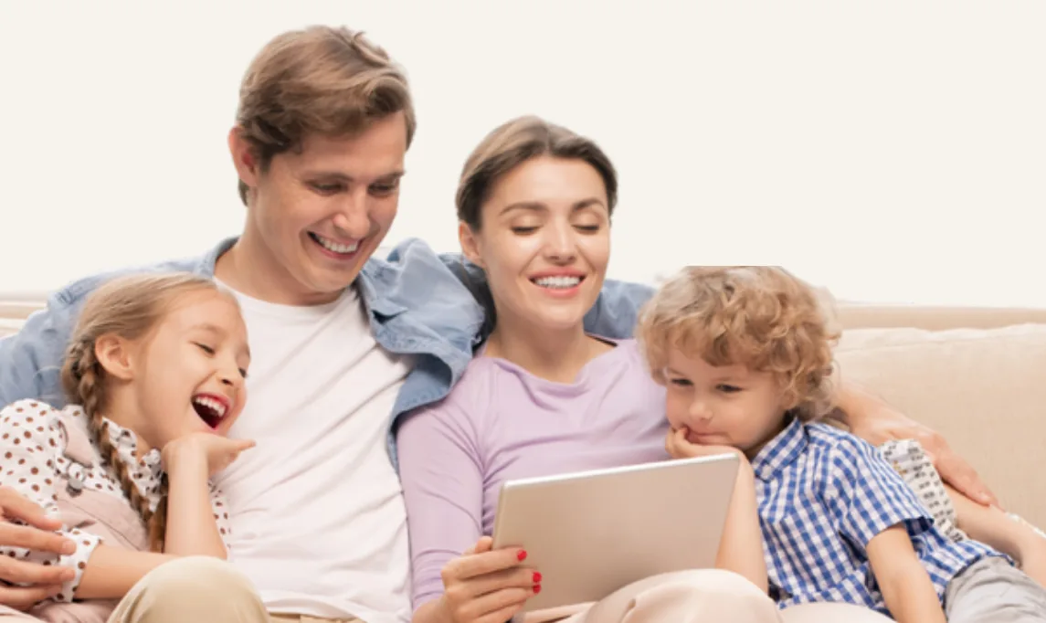 Família sorrindo no sofá enquanto usa um tablet